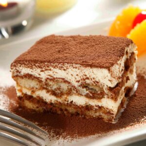 A close-up of a delicious tiramisu dessert dusted with cocoa powder, ready to enjoy.